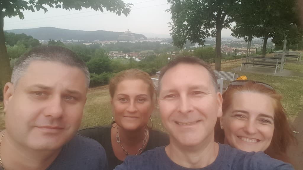 Štvorica pri výhľade na mesto a hrad na kopci v pozadí.
