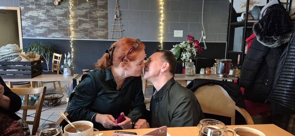 Pár v útulnej reštaurácii, romantický moment pri stole.